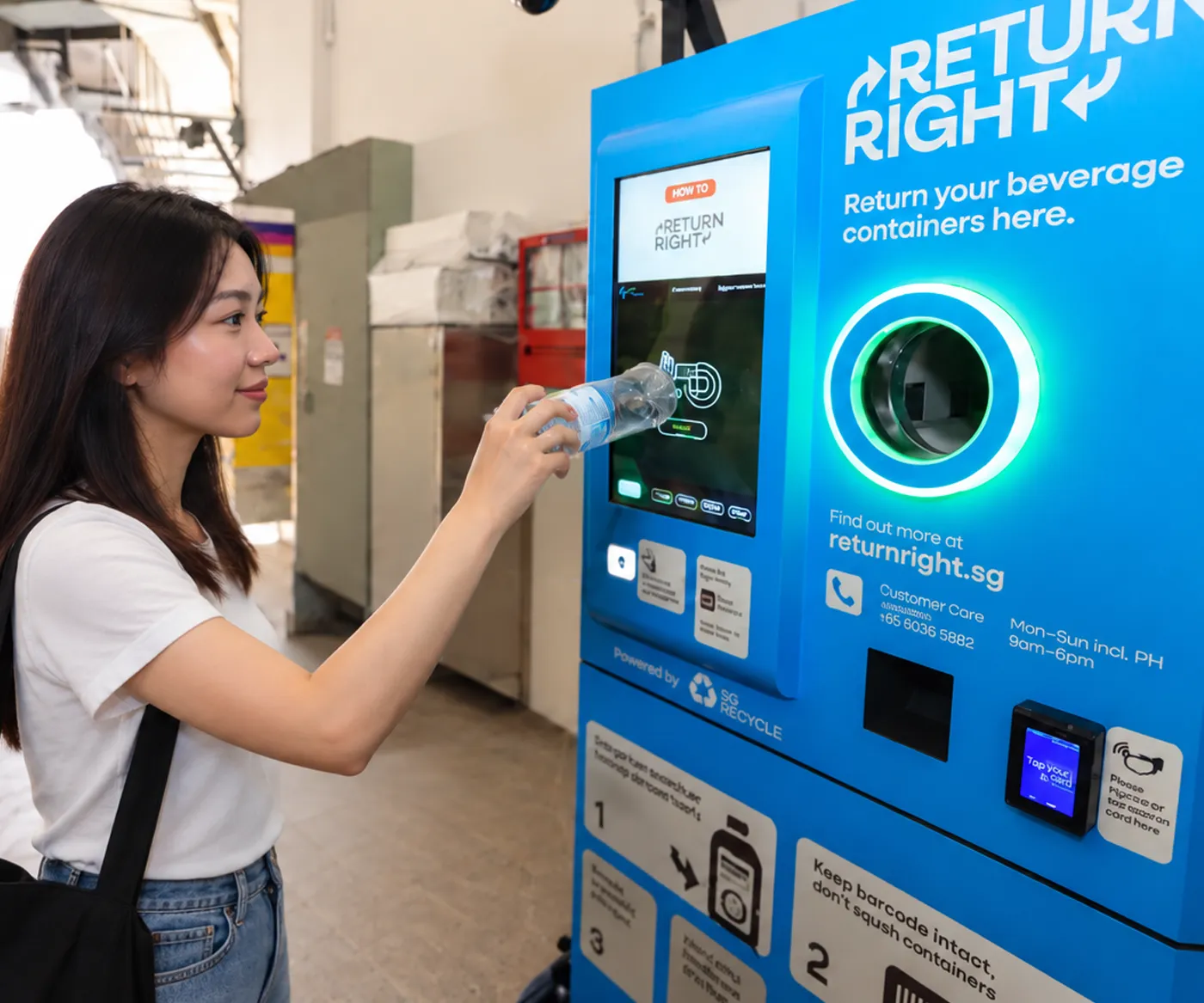 A shopper returning a plastic bottle at a Return Right reverse vending machine in Singapore