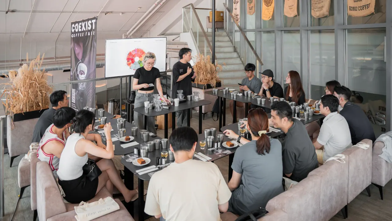 A filter coffee tasting session at Coexist Coffee Co., with guests seated around long tables