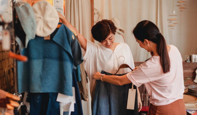 sales lady helping customers choose clothes, improving experience with customer data